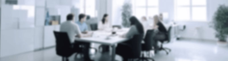 A blurred image about people around a table